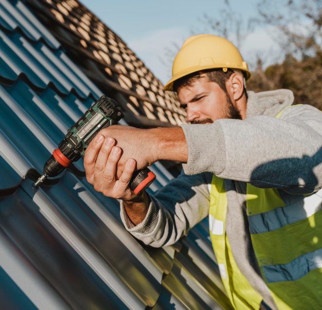 Certified roofer securing metal roof panels with professional installation equipment